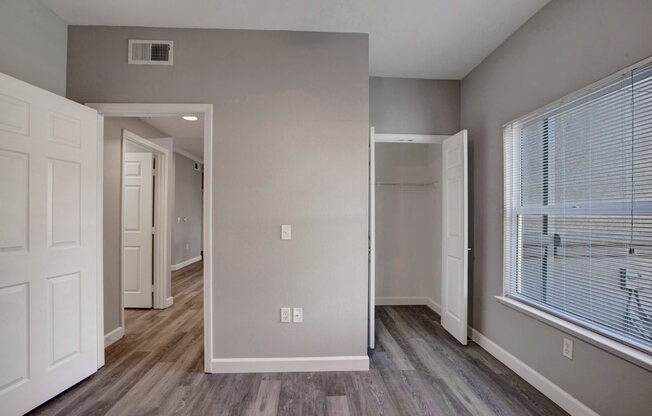 a bedroom with a large window and a closet