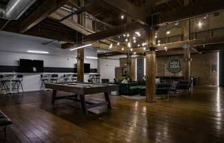 A room with wooden floors and a long table with chairs around it.