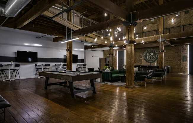 A room with wooden floors and a long table with chairs around it.