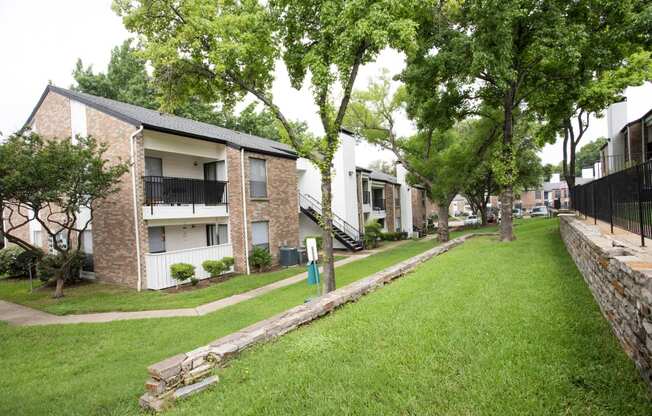 the apartments are located next to a green lawn and trees