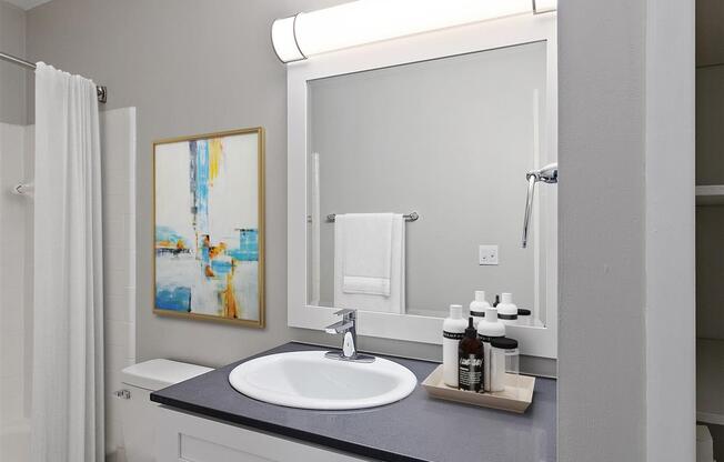 white bathroom with a sink at Town & Country Apartments - Wixom, MI, Wixom