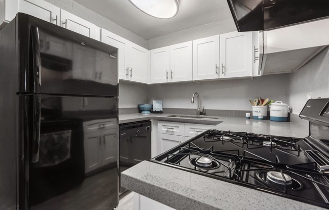 a kitchen with black appliances and white cabinets