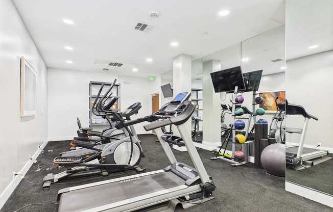 A spacious gym with treadmills, elliptical machines, and other exercise equipment.
