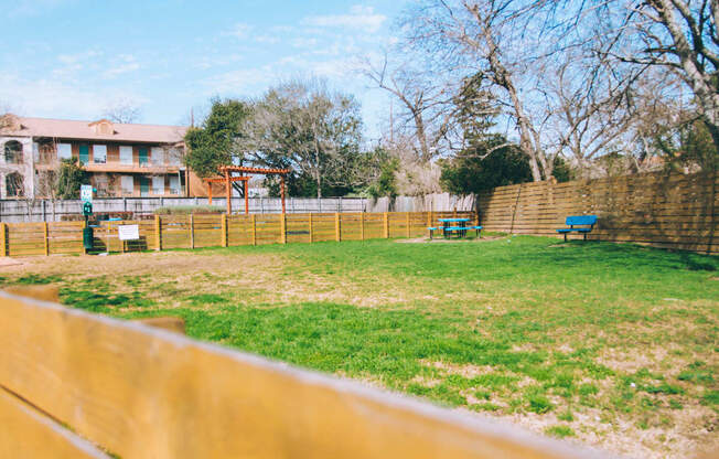 a fenced in backyard with a picnic table and a fence