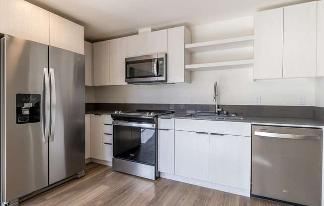 a kitchen with white cabinets and stainless steel appliances at Marina Square, WA 98337
