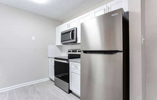 A kitchen with a stainless steel refrigerator, microwave, oven, and dishwasher.