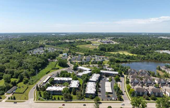 an aerial view of a city with houses and a lake