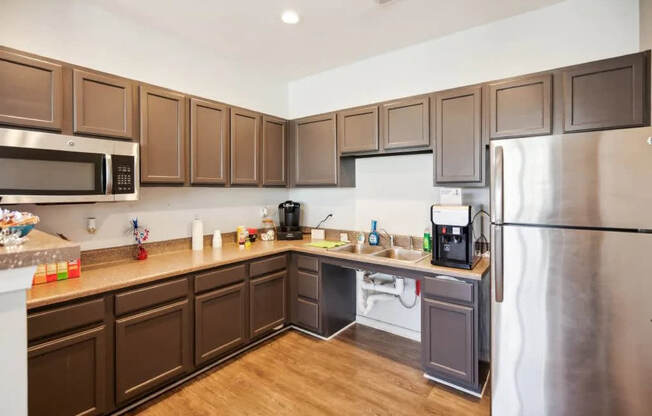 A kitchen with brown cabinets and a stainless steel refrigerator.