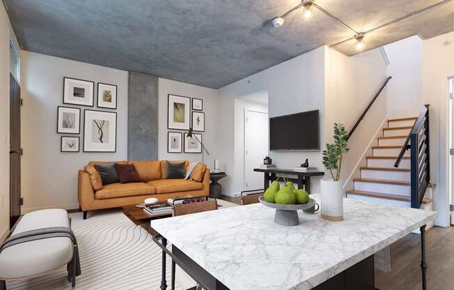A living room with a couch, chair, and a table with fruit on it.