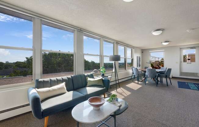 a living room with a couch and a table and windows