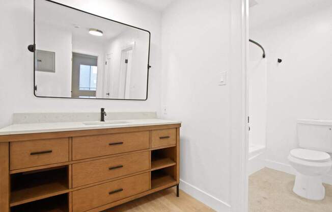 A bathroom with a sink, mirror, and toilet.