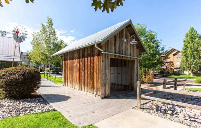 a small wooden building with a garage and a windmill in the background at Mullan Reserve Apartments, Montana, 59808