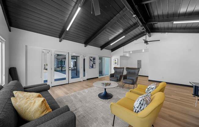 A living room with a grey couch, yellow armchair, and a coffee table.