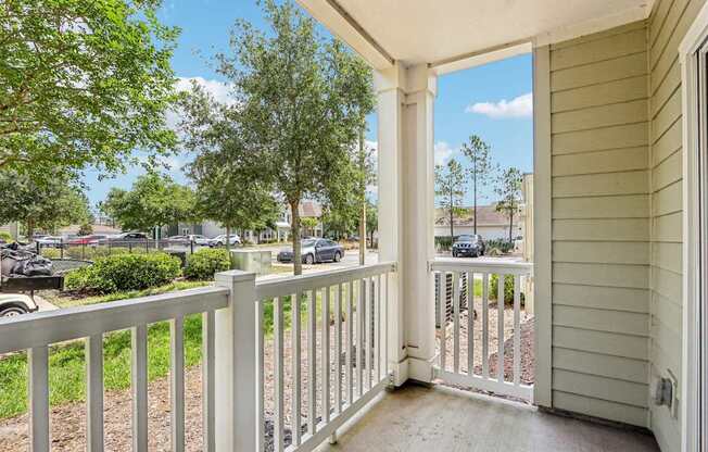 A view from the Royal Palm patio looking out to lush green trees and grass at Oakleaf Plantation Apartments in Jacksonville, FL