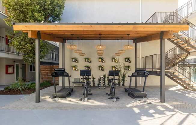 a fitness center with weights machines and a wood roof