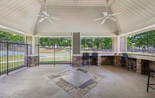 A covered patio with a table and chairs.