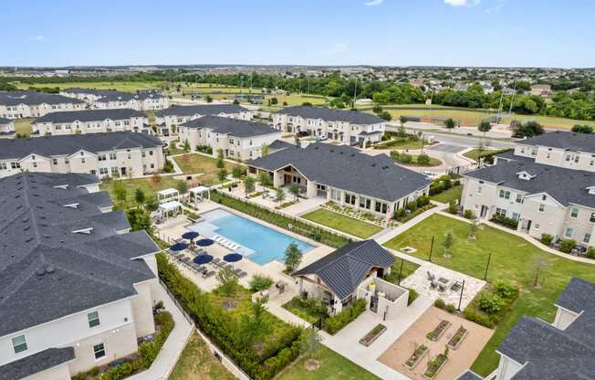 an aerial view of a group of houses and a swimming pool