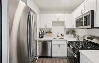 a kitchen with stainless steel appliances and white cabinets