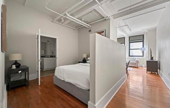 A bedroom with a bed, nightstand, and chair.