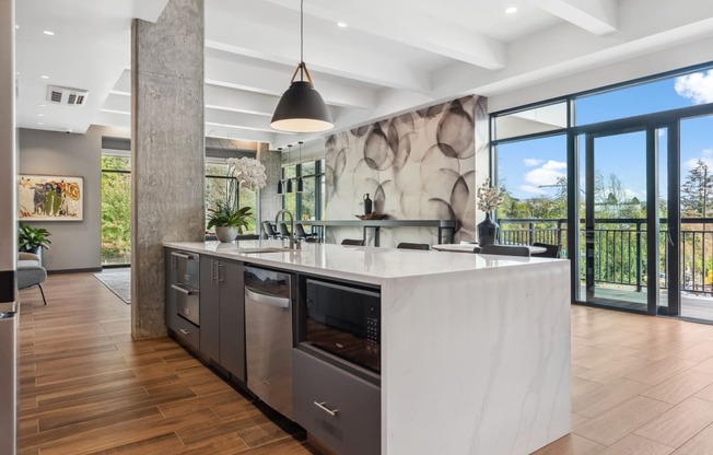 A modern kitchen with a large island and a view of the outdoors.