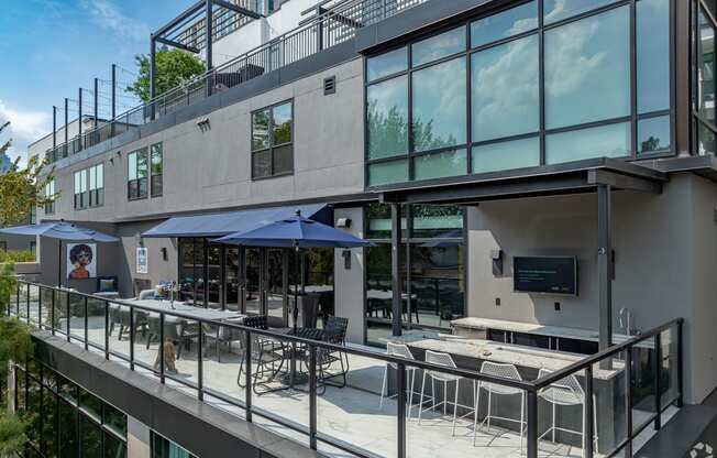 an exterior view of a building with tables and umbrellas