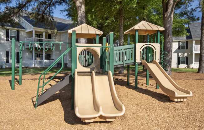 a playground with slides and swings in front of a house