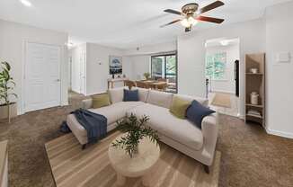 A living room with a white couch and a ceiling fan.
