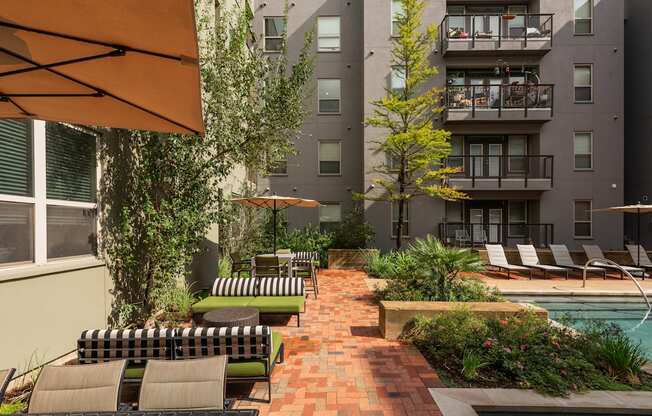 a courtyard with a pool and lounge chairs