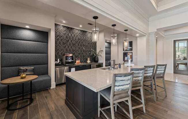 A modern kitchen with a large island and chairs.