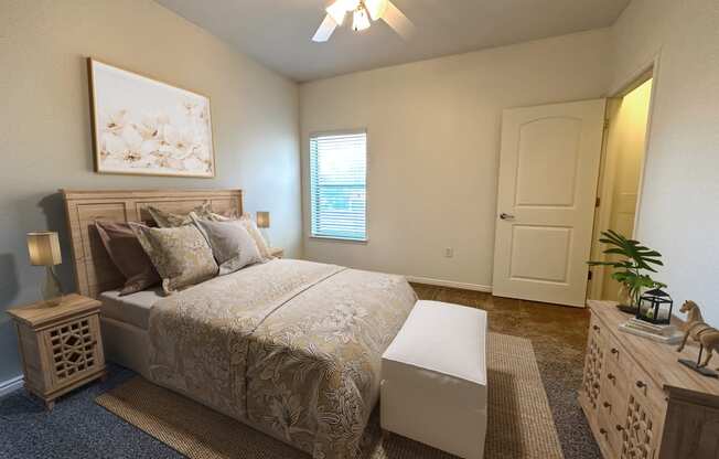 Liberty Landing Apartments in West Jordan Utah bedroom with a full-sized bed and ceiling fan.