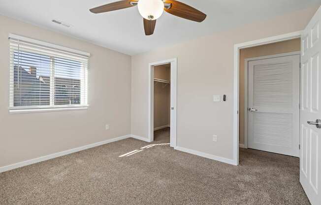 Bedroom with ceiling fan and carpeted floor at Olde English Village