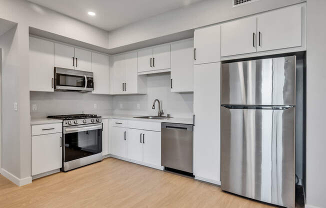 A modern kitchen with stainless steel appliances and white cabinets.
