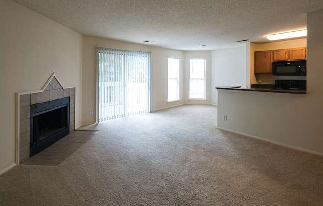 A living room with a fireplace and patio door leading out to a private patio