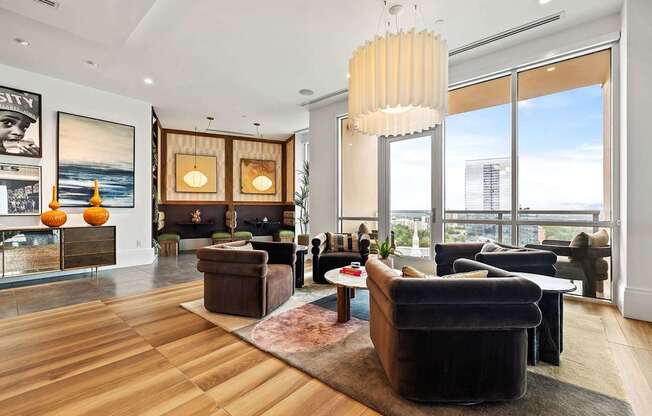 A living room with a large window and a view of the city.