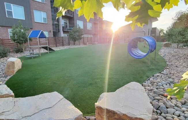 the backyard of an apartment building with a playground and a frisbee