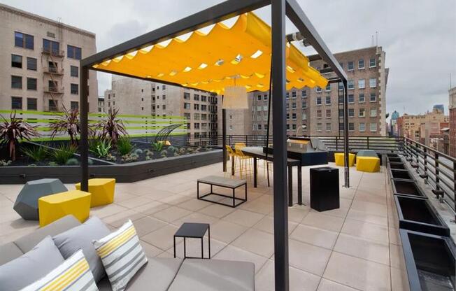 a rooftop patio with couches and a ping pong table