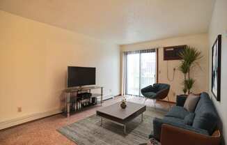 a living room with a couch coffee table and tv. Fargo, ND Westwood Estates Apartments