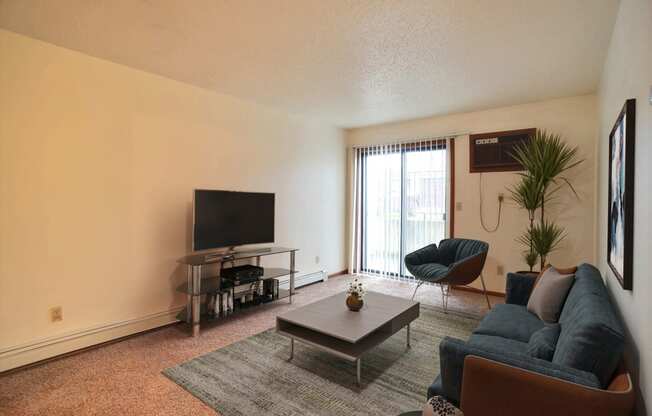 a living room with a couch coffee table and tv. Fargo, ND Westwood Estates Apartments