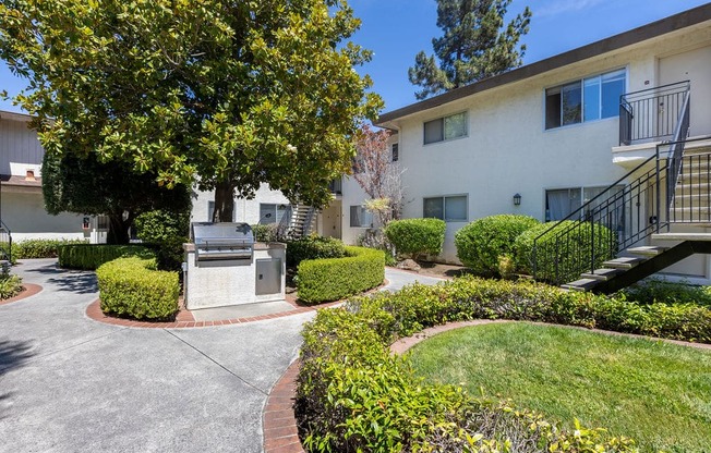 a building with a driveway and a tree in front of it