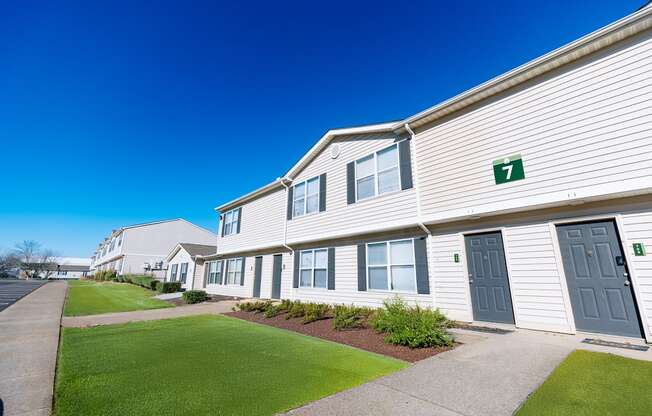 A row of houses numbered in order with green numbers.