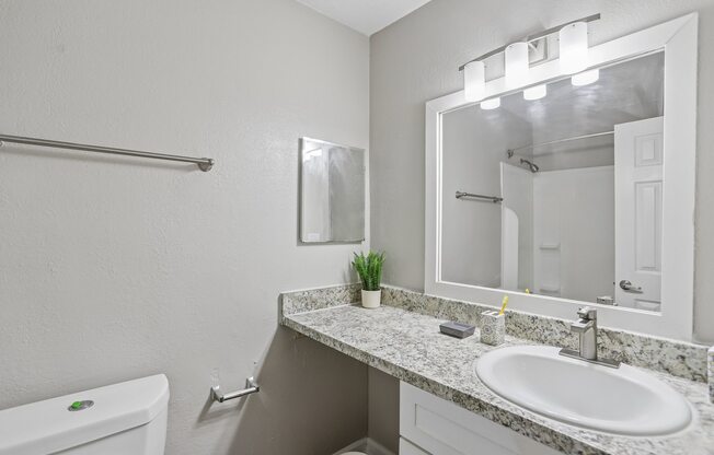 A bathroom with a white sink and a white toilet.