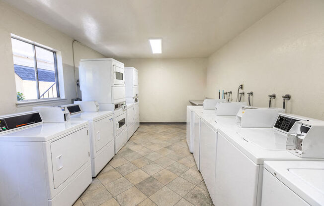 a laundry room with washes and dryers and a window