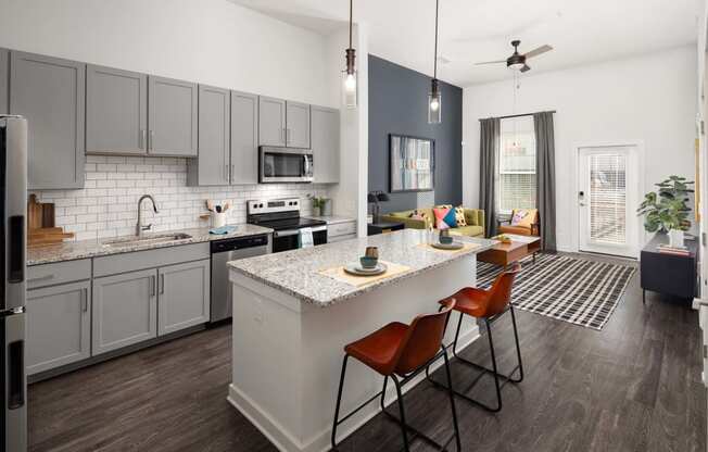 an open kitchen and living room with an island and chairs