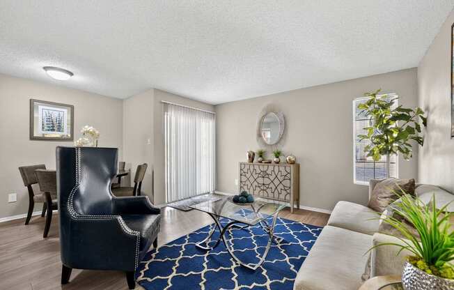 A living room with a black leather chair and a blue and white patterned rug.