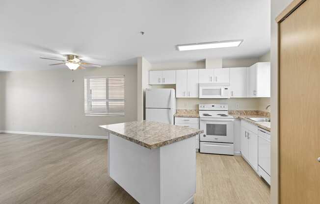 Very Large, Spacious kitchen area with white cabinetry and an island at Promenade at the Park Apartment Homes, WA 98125