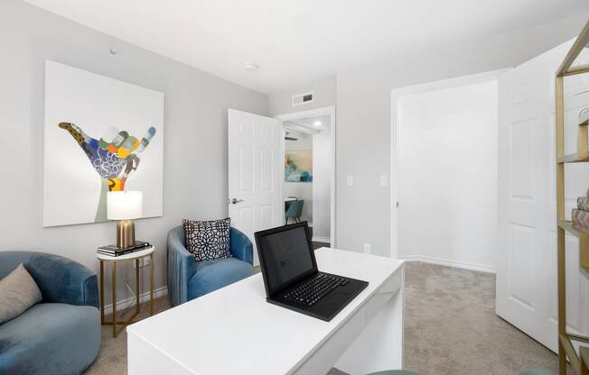 a living room with a desk with a laptop on it