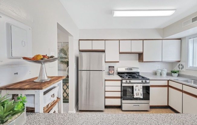a kitchen with white cabinets and stainless steel appliances