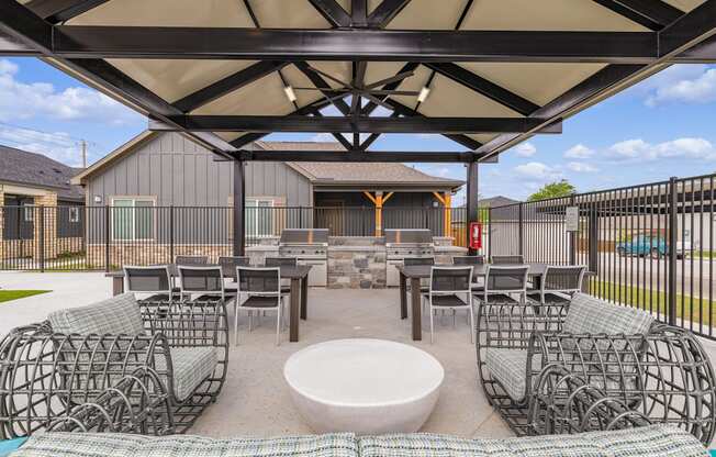 A patio with a table and chairs under a canopy.