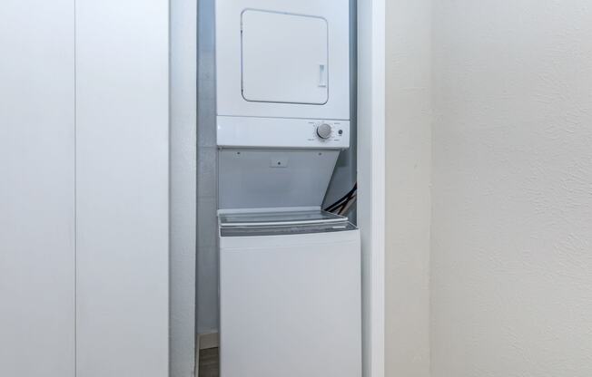 a small refrigerator with a washer and dryer