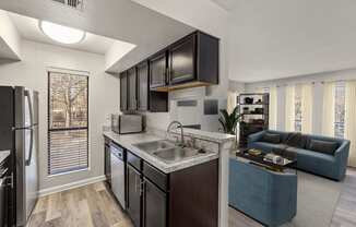 a kitchen and living room with a sink and a refrigerator